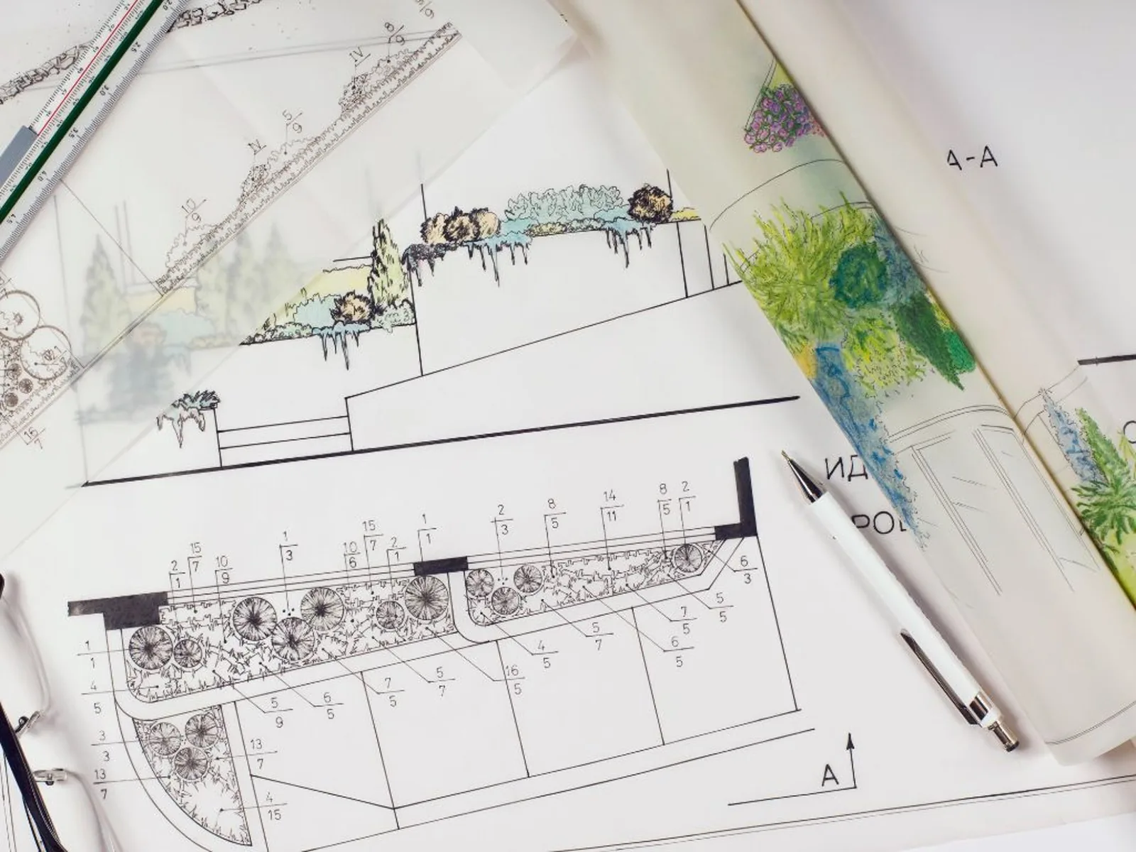 Handgezeichnete Bepflanzungspläne und Schnittzeichnungen mit Lineal und Stift auf dem Schreibtisch